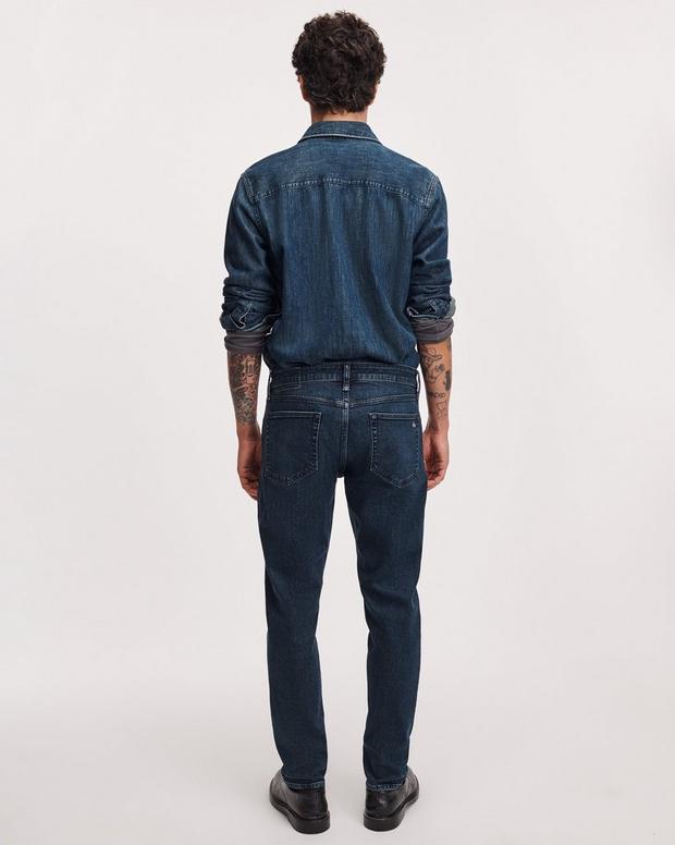 Back view of man wearing dark indigo Rag and Bone Fit 3 Athletic Jean with denim jacket