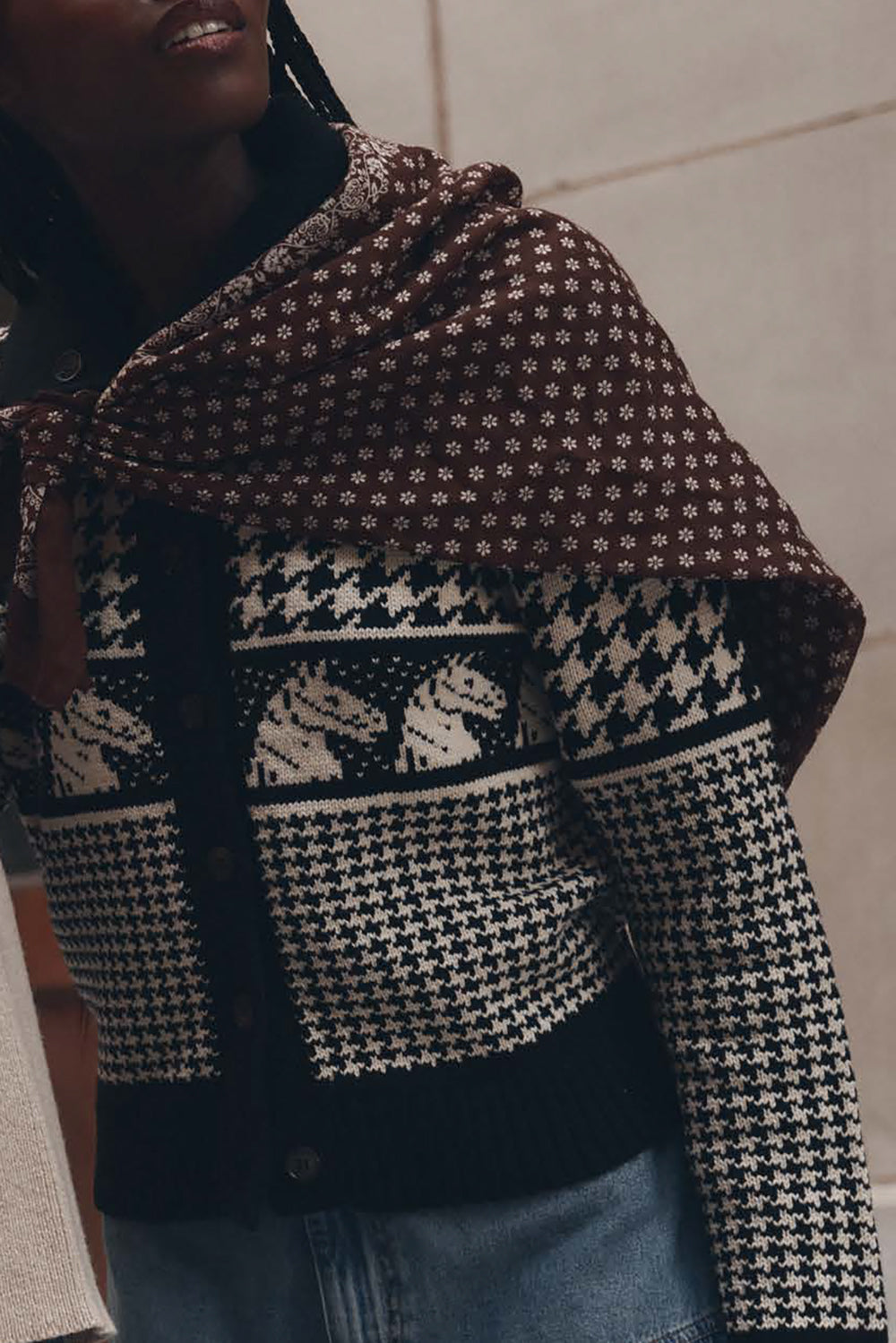 Close-up of black and cream Fair Isle pony motif knit cardigan worn with brown floral scarf