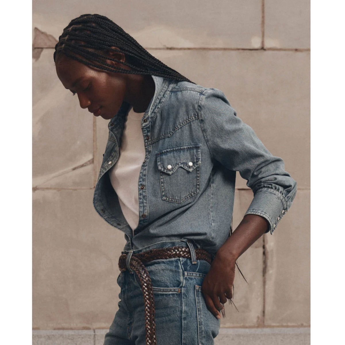Model wearing The GREAT Howdy Top in Oldham Wash light blue denim with braided belt