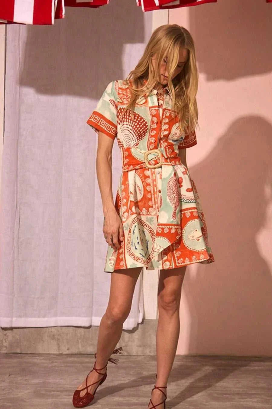 Woman wearing Hunter Bell Liza dress in colorful orange and mint patchwork print