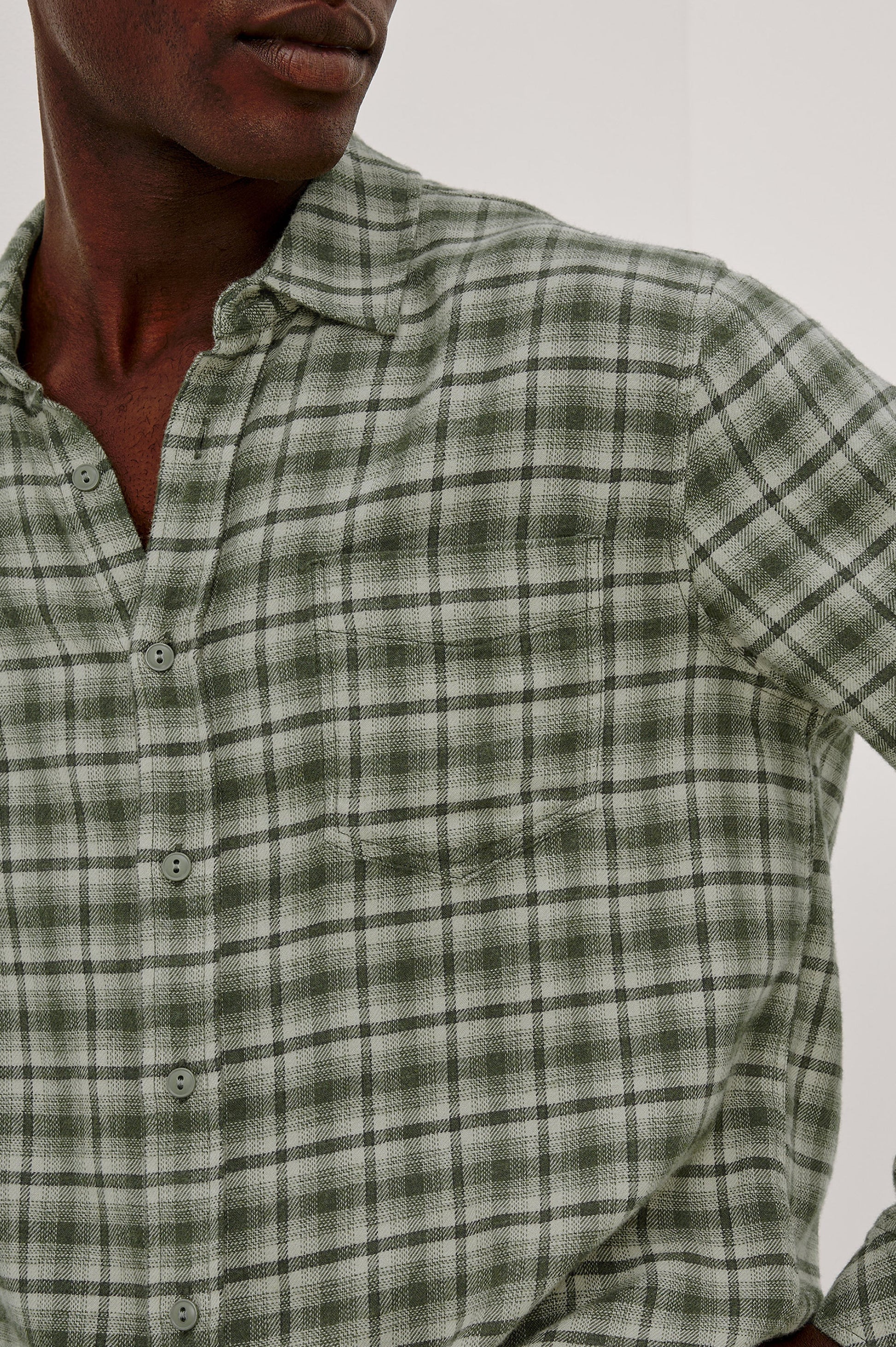 Man wearing Rails Lennox long sleeve plaid shirt in birch forest green check pattern