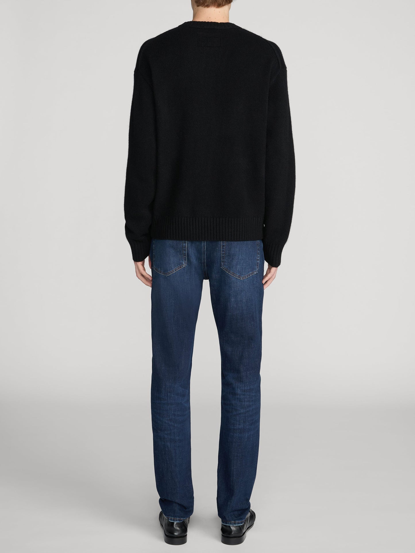 Back view of Frame L'Homme Slim jeans in dark blue wash on male model