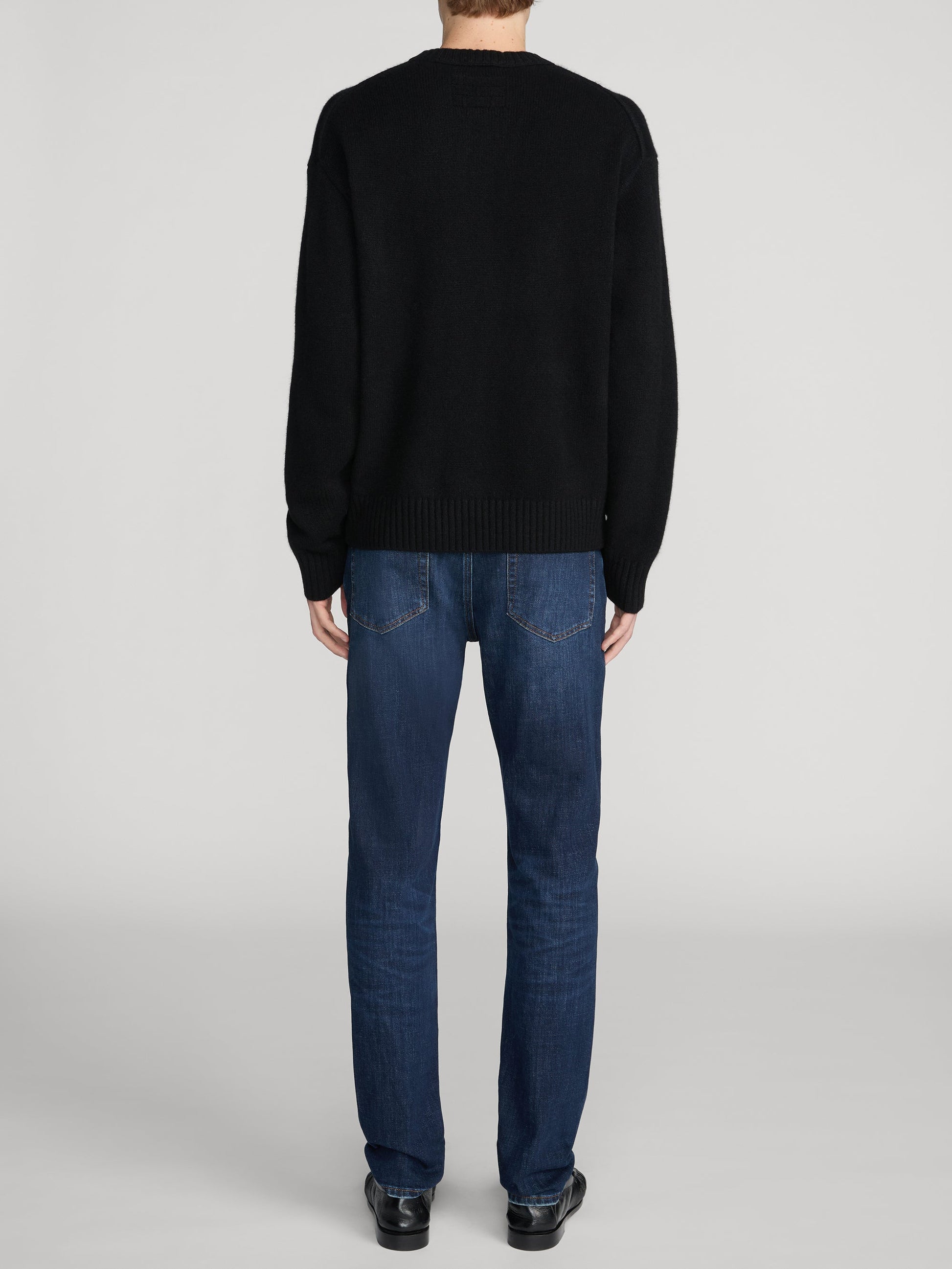 Back view of Frame L'Homme Slim jeans in dark blue wash on male model