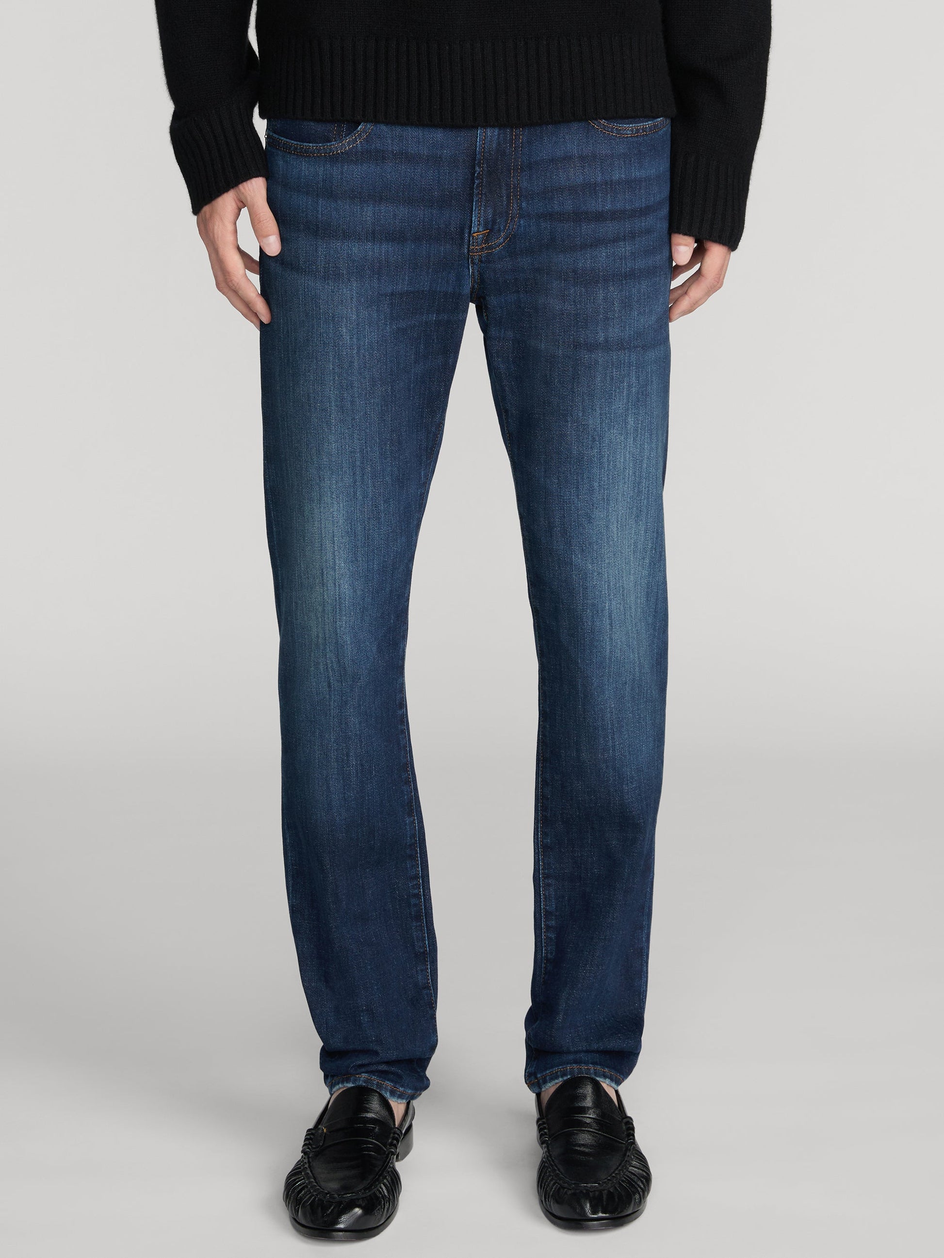 Man wearing Frame L'Homme Slim Lasting dark indigo blue jeans with black loafers