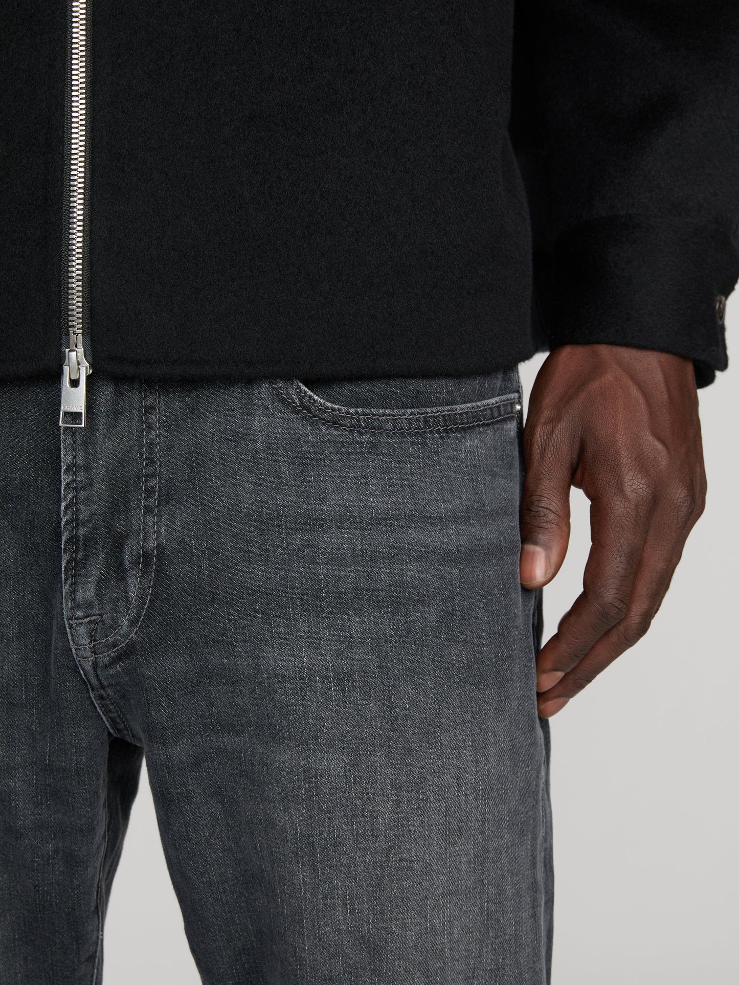 Close-up detail of Frame L'Homme Slim jeans in dark grey midnight ash wash