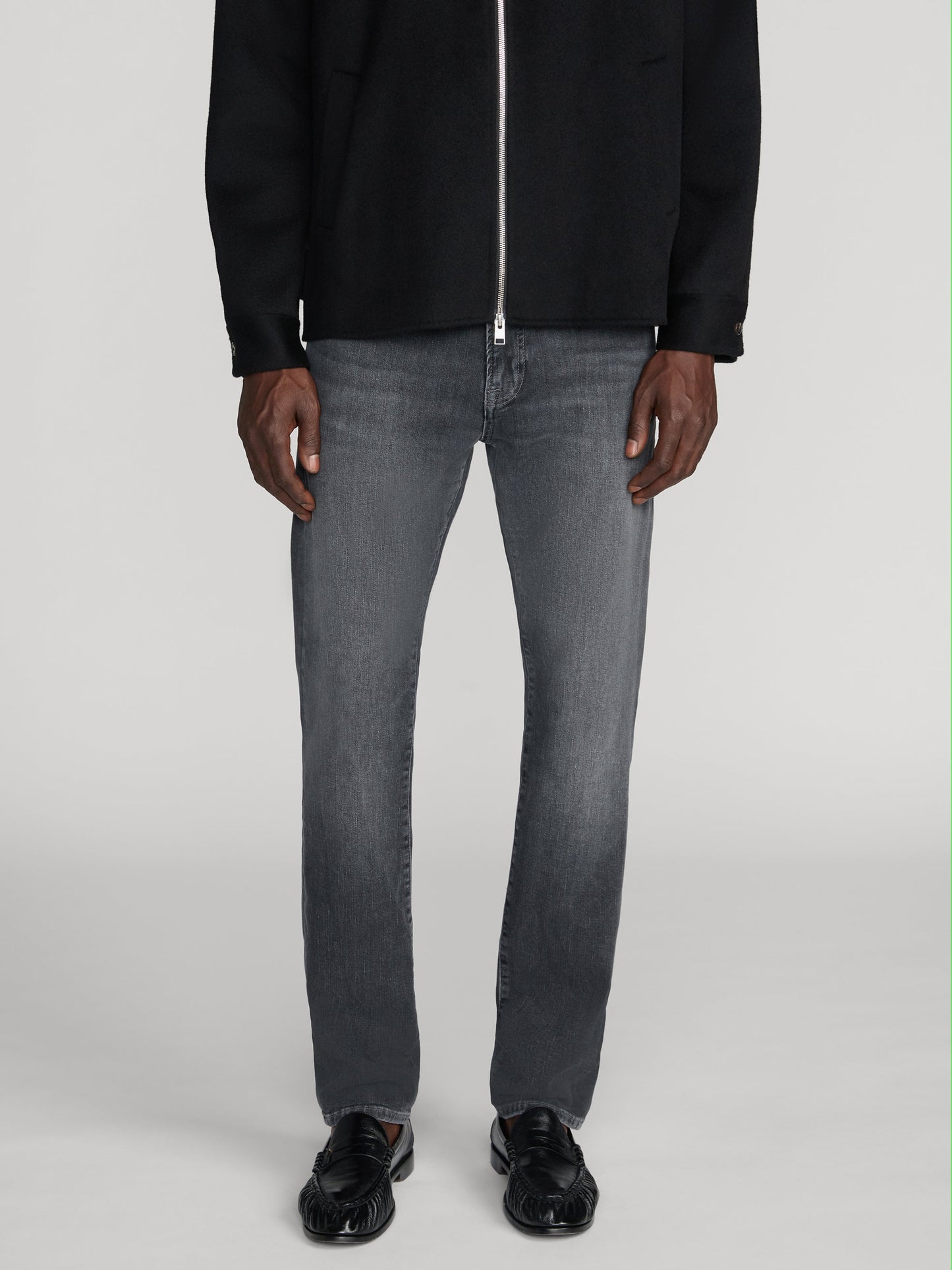 Male model wearing Frame L'Homme Slim jeans in washed grey Midnight Ash colorway