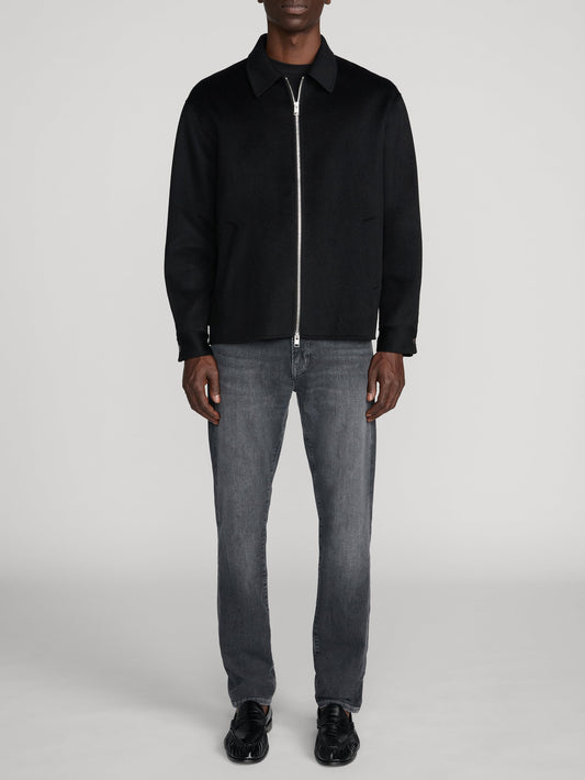 Man wearing Frame L'Homme Slim jeans in Midnight Ash grey wash with black zip jacket
