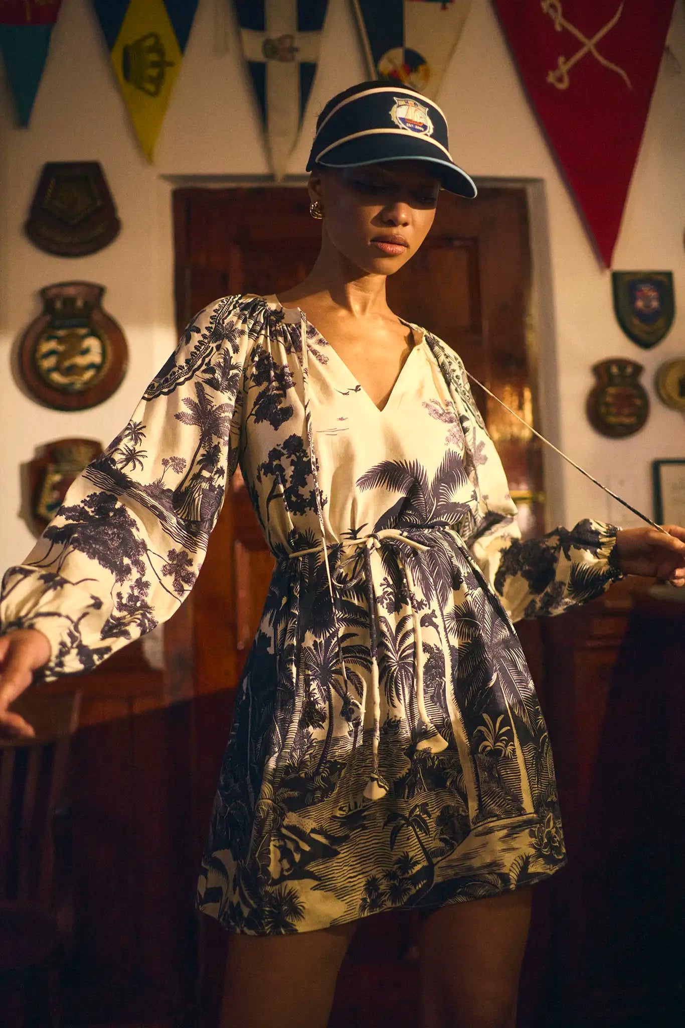 Model wearing Hunter Bell Lisette Dress in Bermuda Toile print with tropical palm motifs