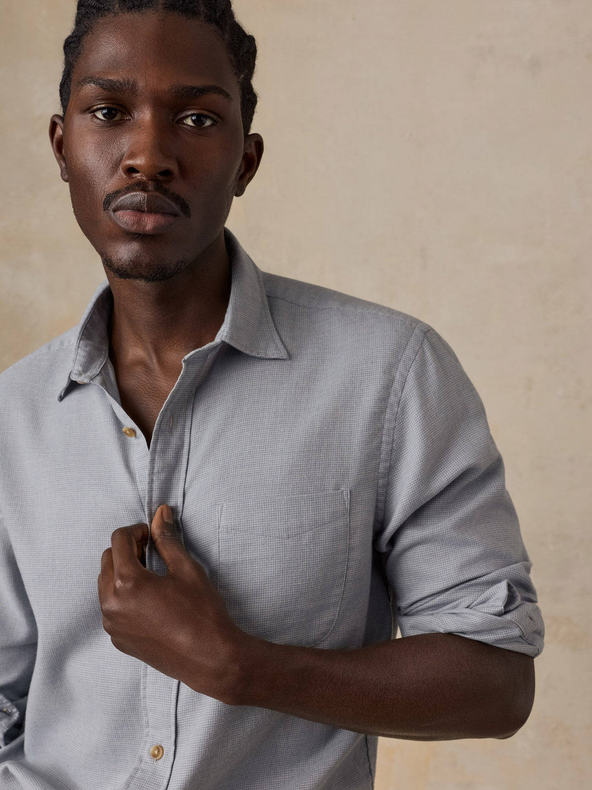 Male model wearing Faherty Timberline Brushed Twill Shirt in mineral grey with rolled sleeves