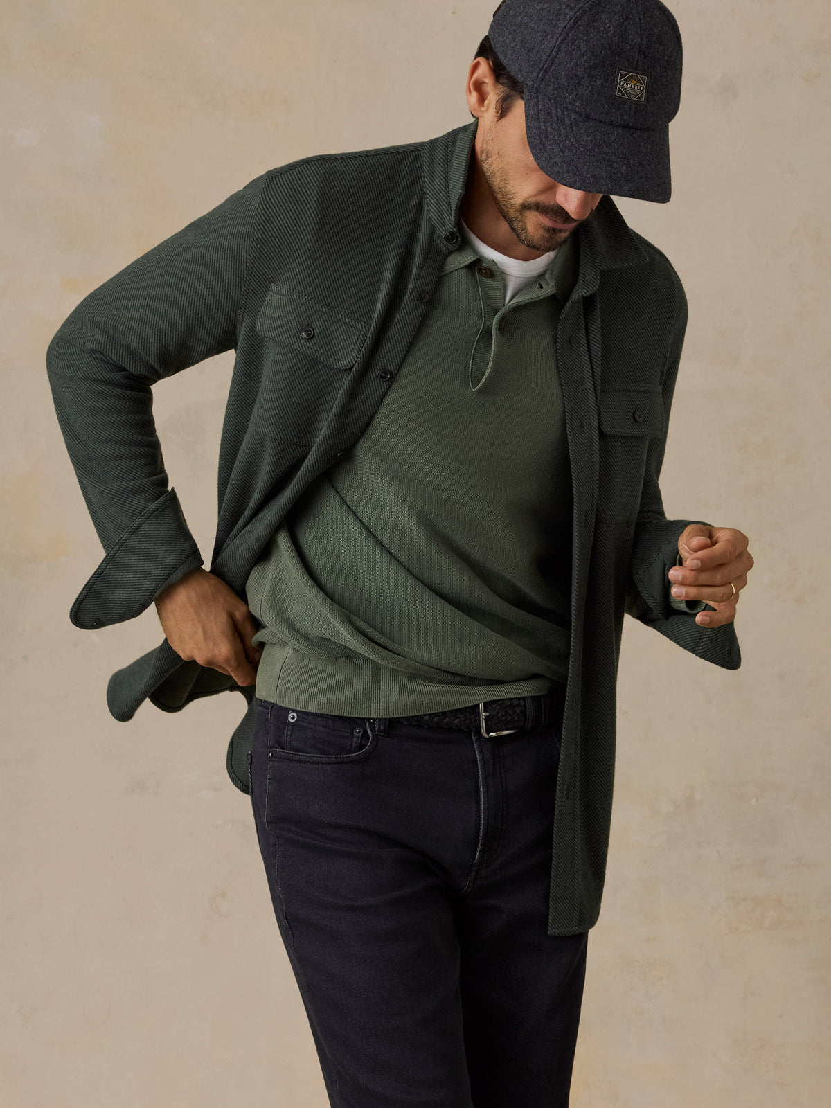 Male model wearing Faherty Legend Sweater Shirt in dark green twill over polo with dark jeans