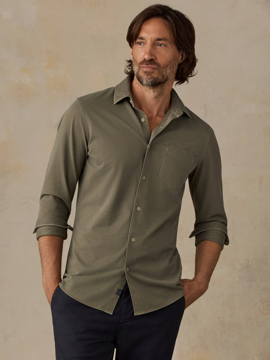 Man wearing Faherty Costa Piqué Shirt in Ridge Olive with sleeves rolled up