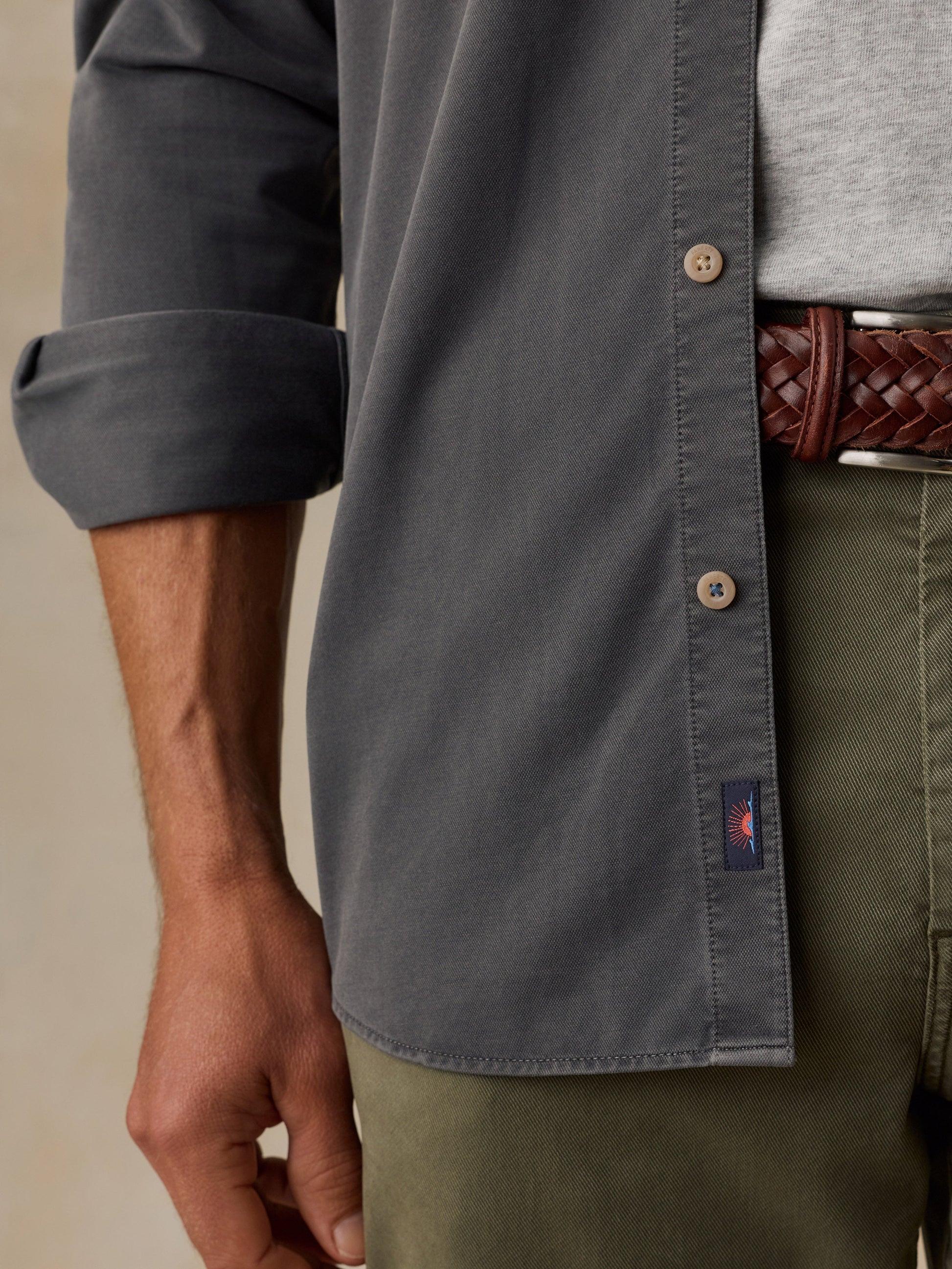 Close-up detail of Faherty Costa Piqué shirt in slate gray with rolled sleeves and tan buttons