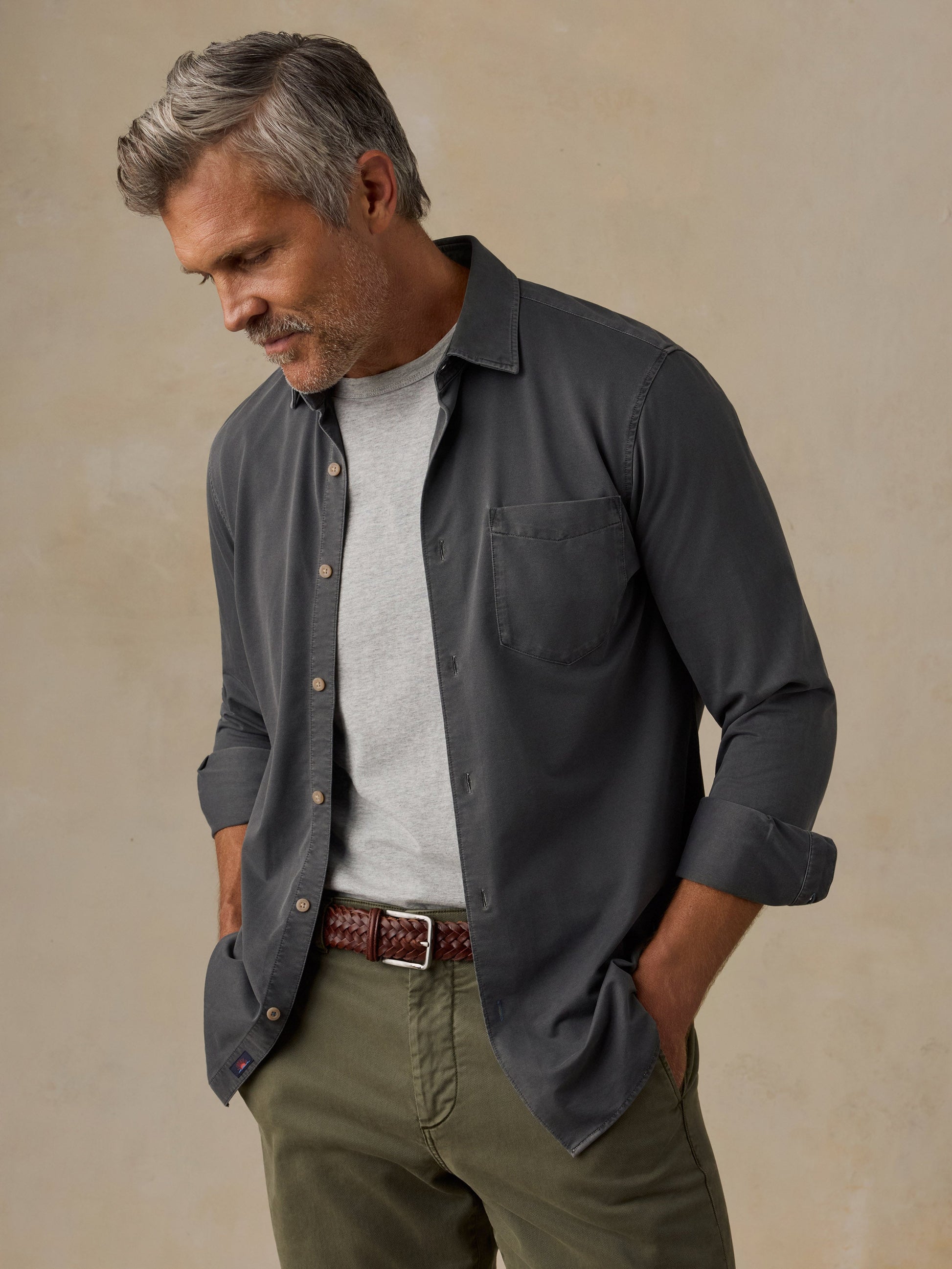 Male model wearing Faherty Costa Piqué Shirt in dark charcoal Ridge Black, open over grey tee