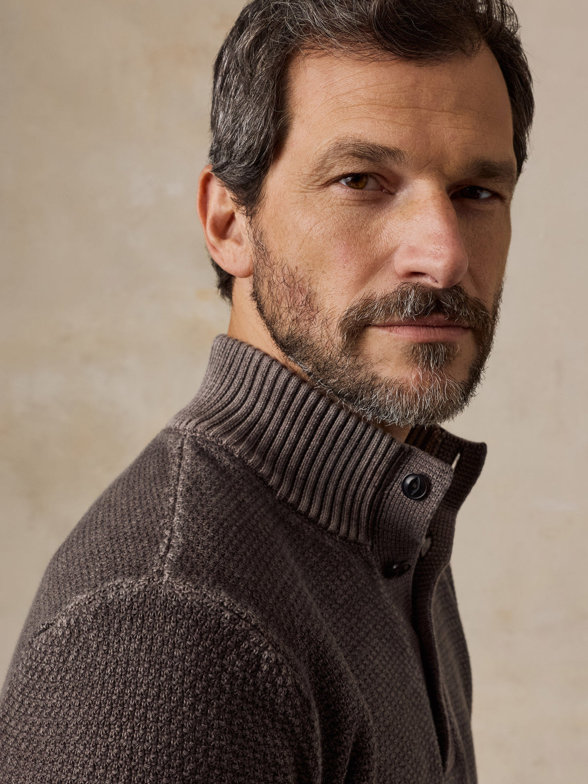 Male model wearing Faherty Sunwashed Dockside Quarter Button sweater in Coast Brown