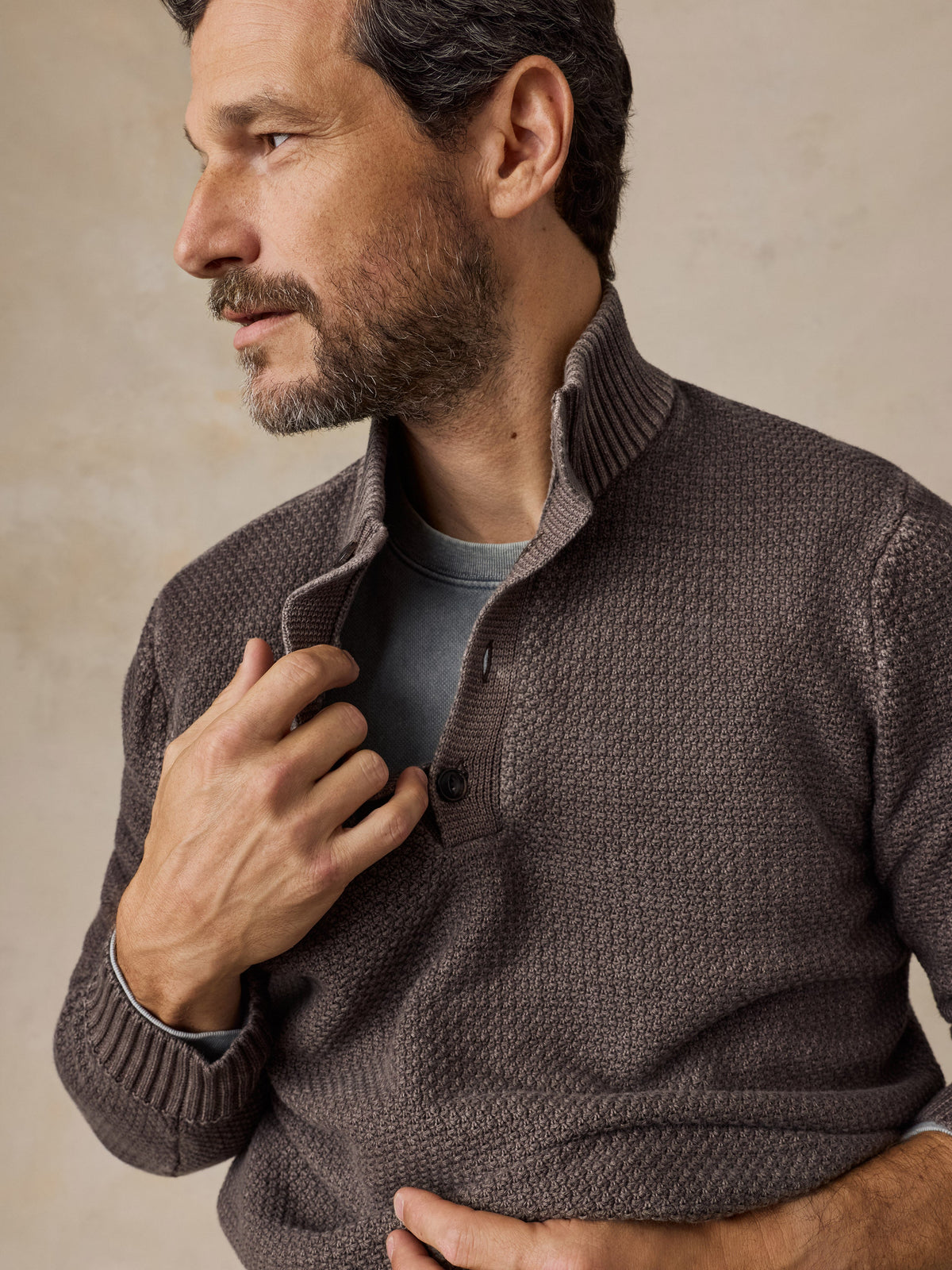 Man wearing Faherty Sunwashed Dockside Quarter Button sweater in Coast Brown with ribbed collar
