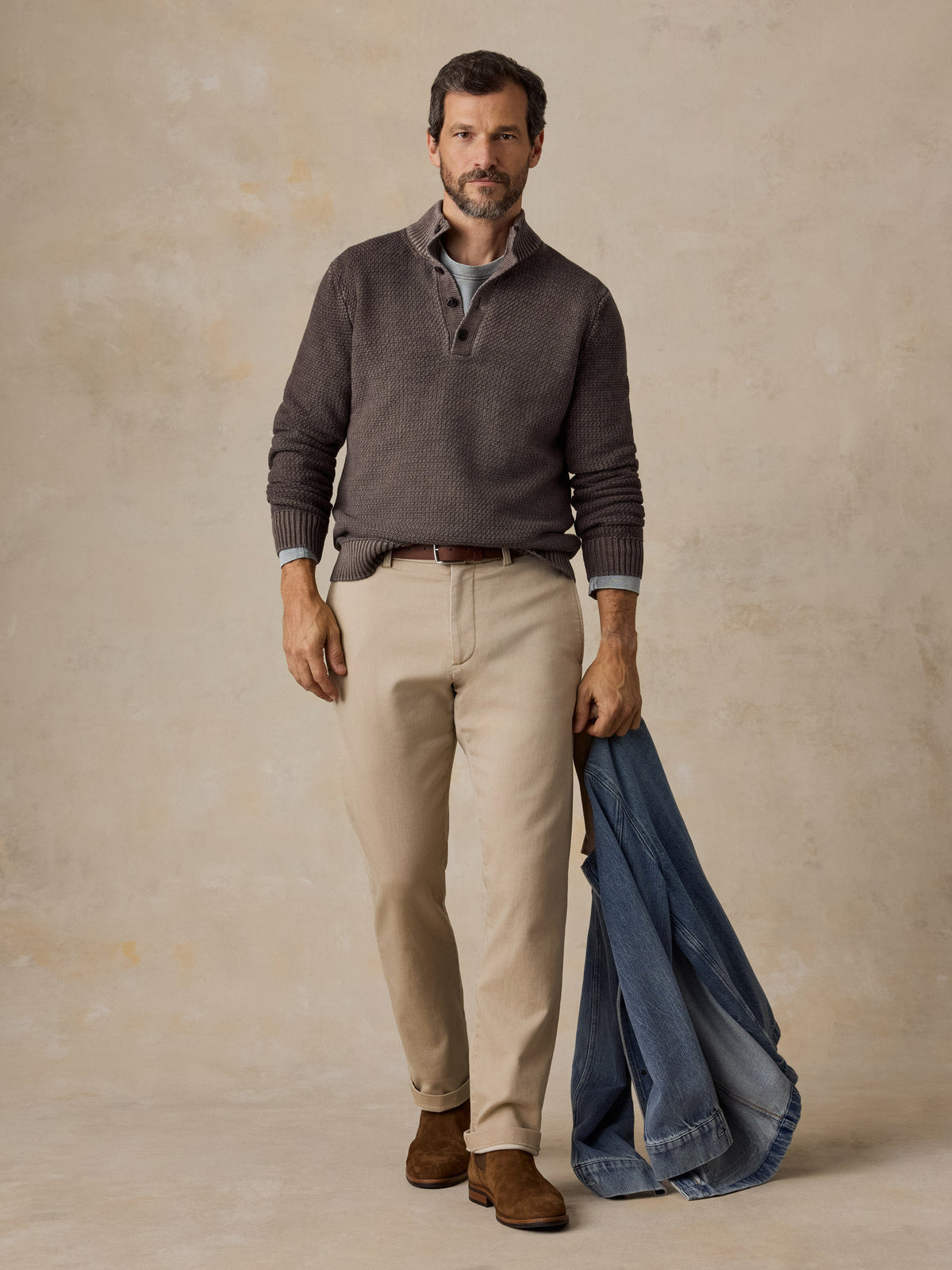 Male model wearing Faherty Sunwashed Dockside Quarter Button sweater in Coast Brown with khaki pants