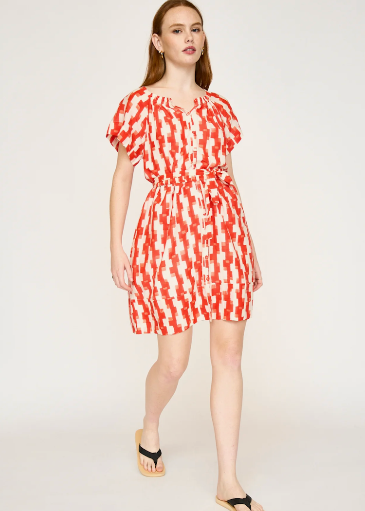 Woman wearing red and white patterned short sleeve dress with belt