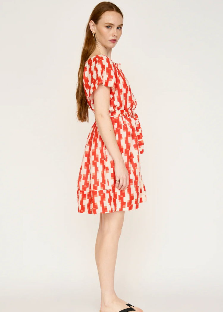 Woman wearing red and white geometric print short sleeve dress with belt