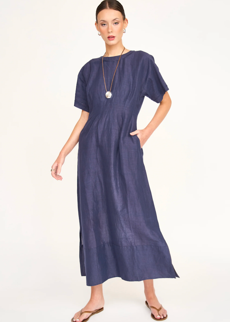 Woman wearing navy blue midi dress with short sleeves and long necklace