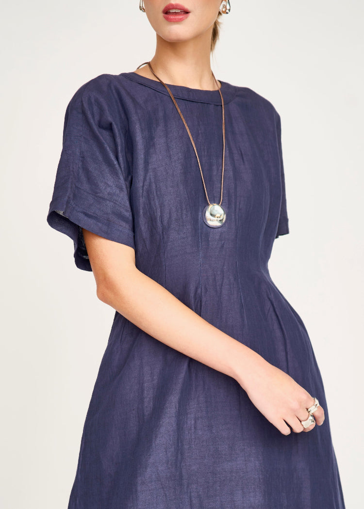 Woman wearing navy blue Mirth Wailea dress with pendant necklace