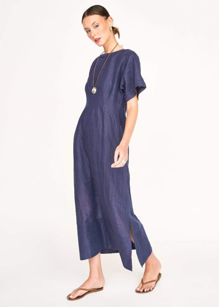 Woman wearing navy blue midi dress with short sleeves and side slit