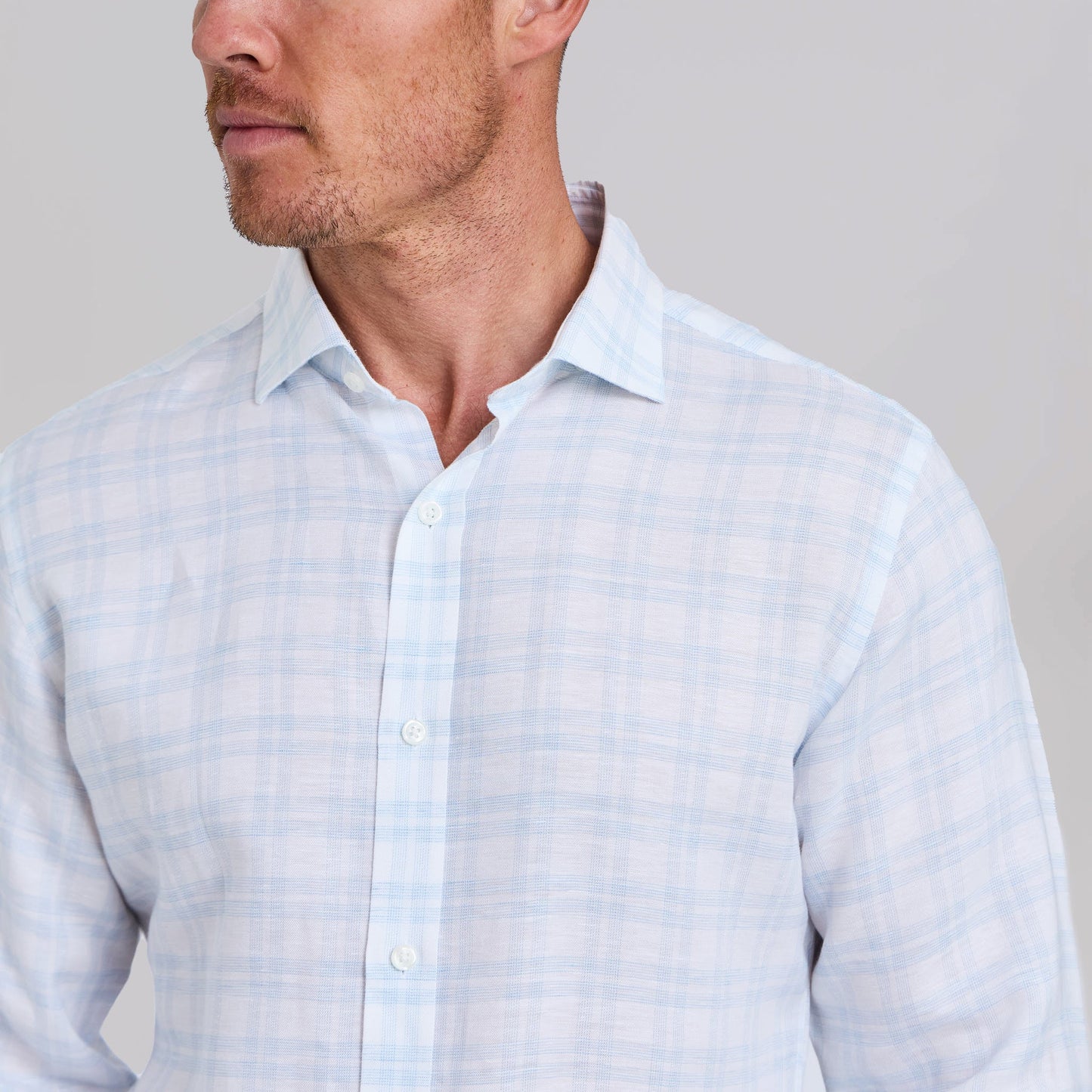 Man wearing white dress shirt with light blue plaid pattern