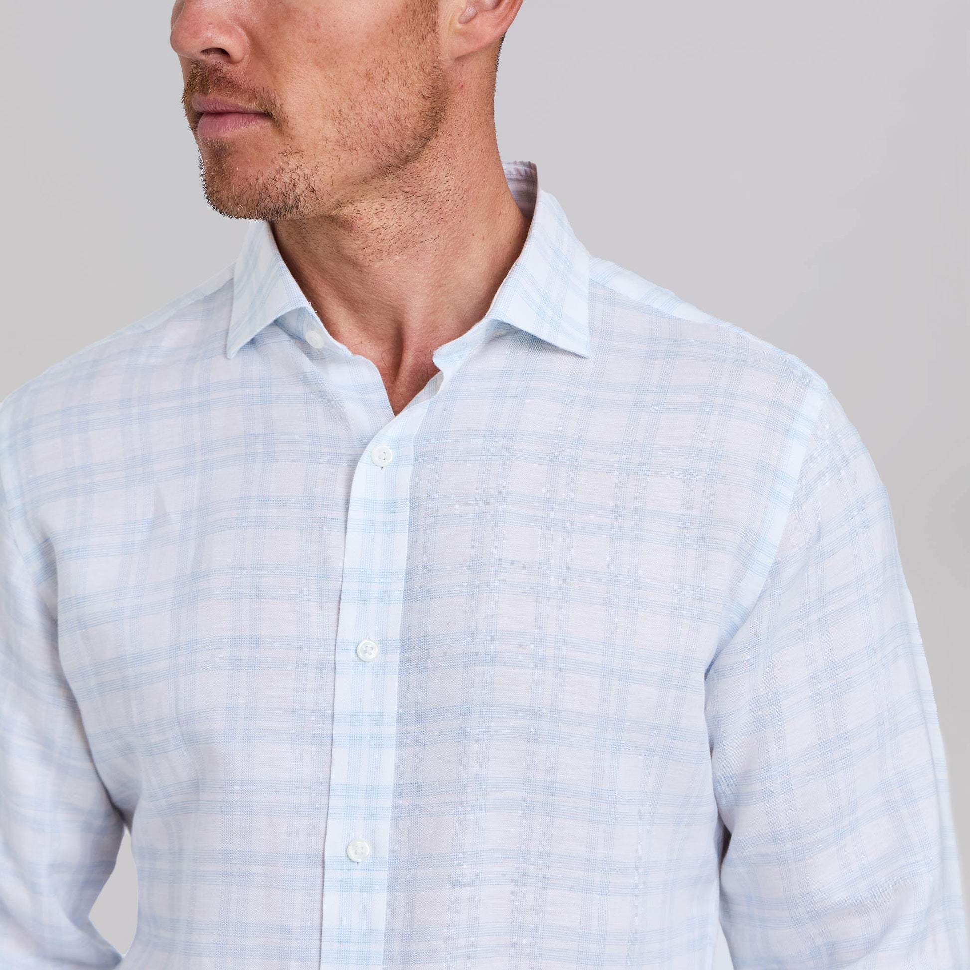 Man wearing white dress shirt with light blue plaid pattern