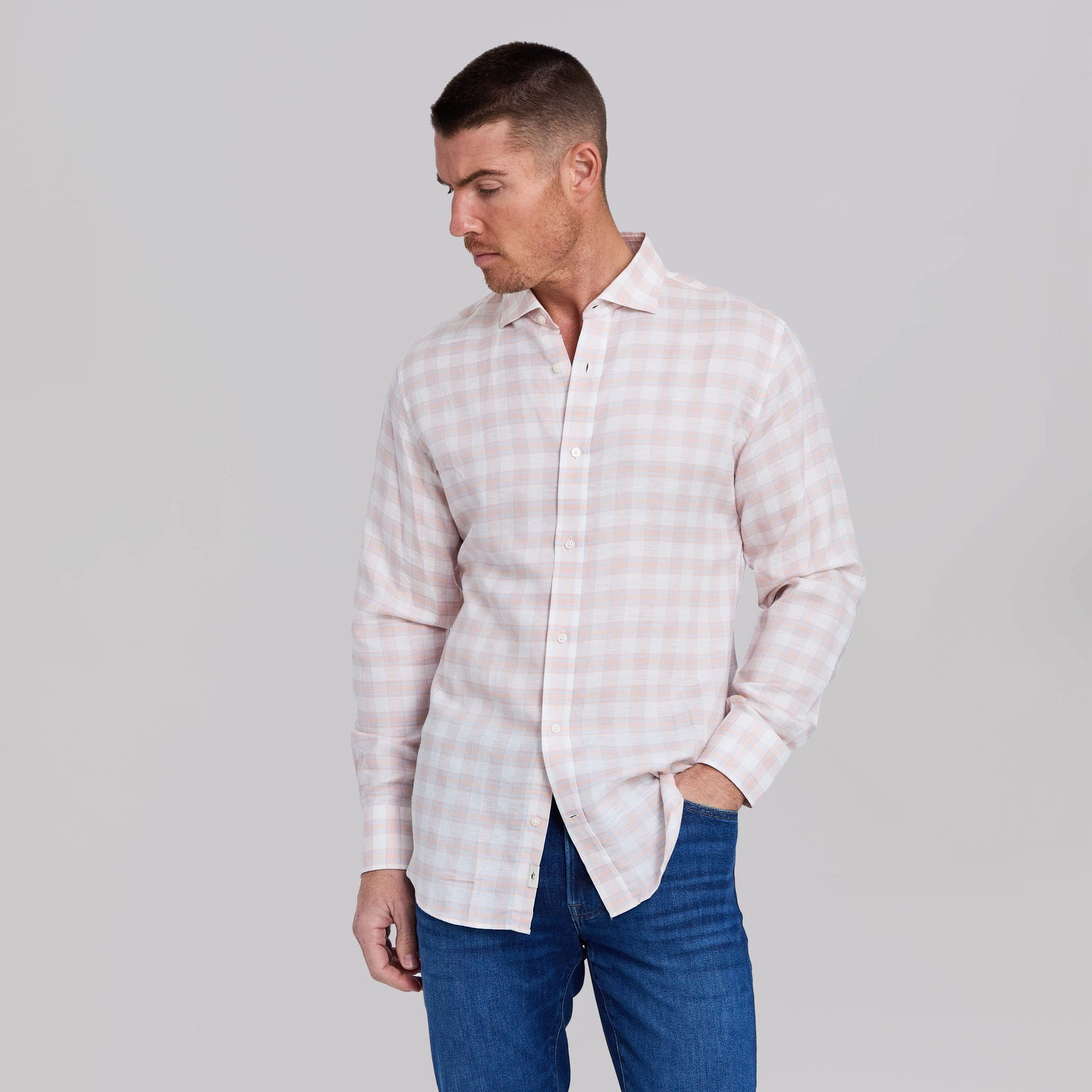 Man wearing peach and light blue plaid stretch linen sport shirt with jeans