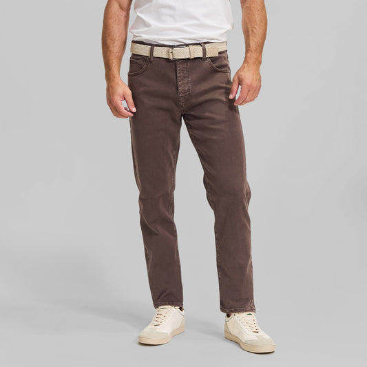 Man wearing brown washed 5-pocket pants with white t-shirt and cream sneakers