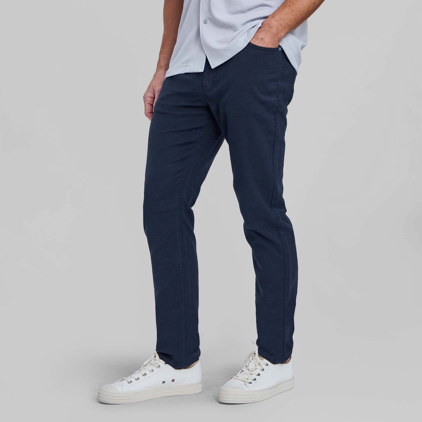 Man wearing navy blue feather terry five pocket pants with white sneakers