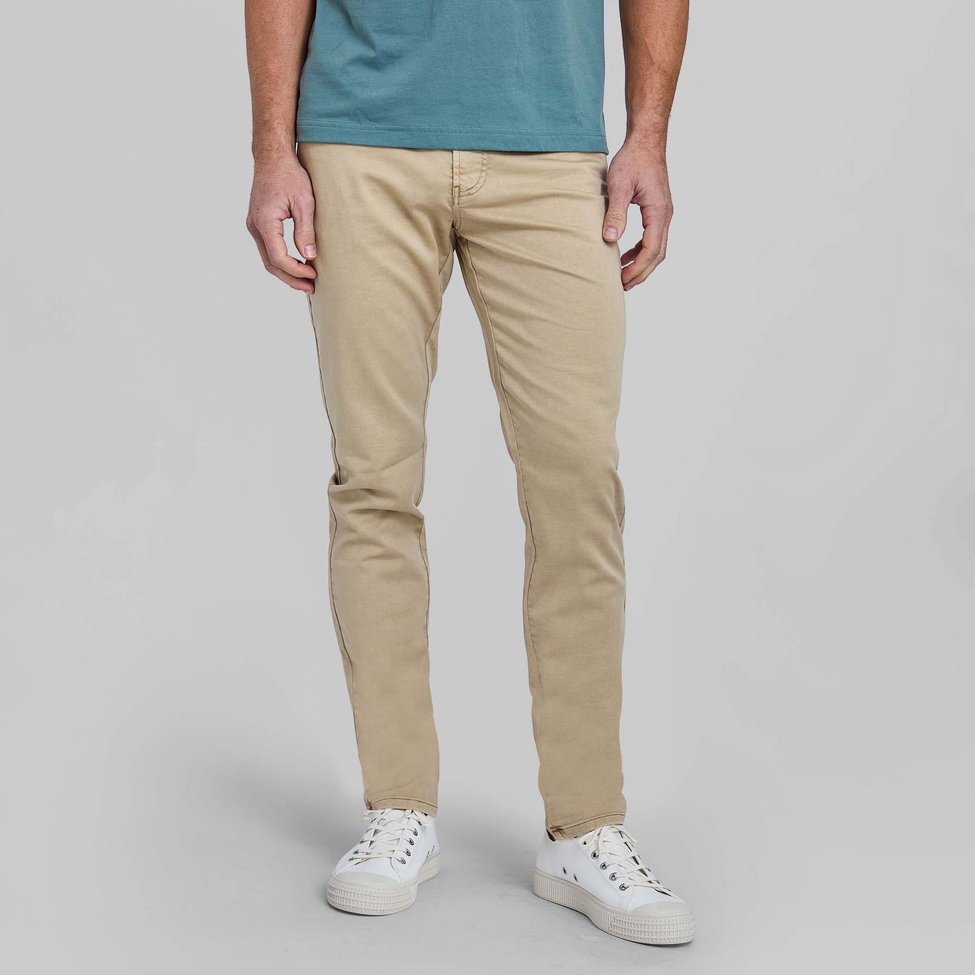 Man wearing wheat colored flex terry comfort stretch five pocket pants with blue shirt
