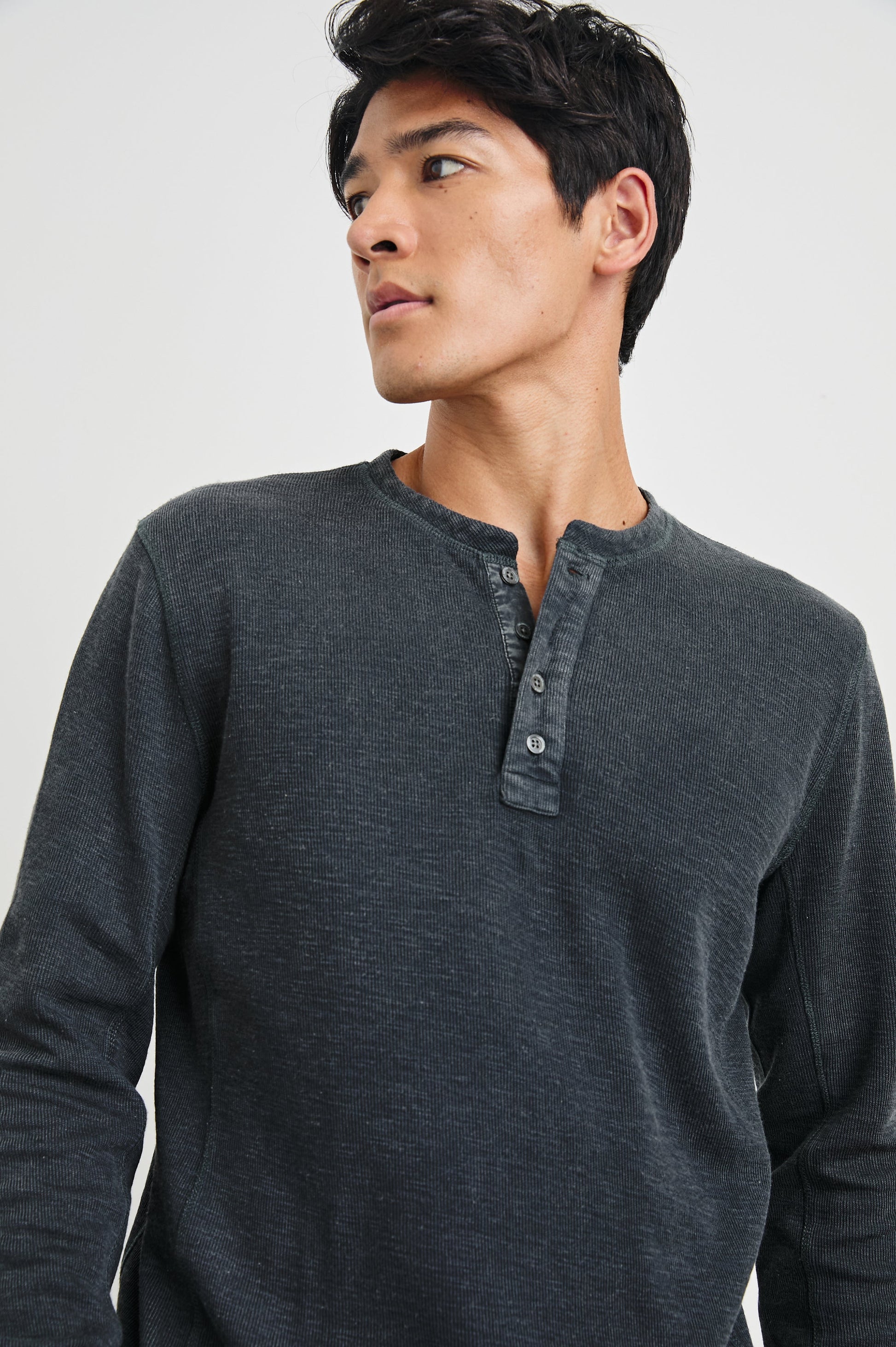 Male model wearing Rails Soto long-sleeve henley in washed black ribbed fabric
