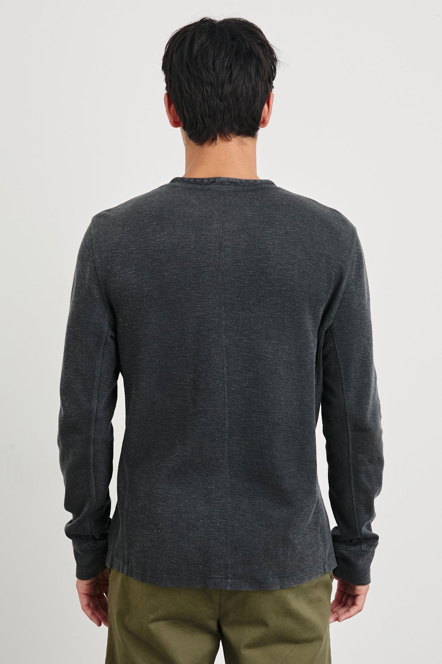 Back view of male model wearing Rails Soto long-sleeve henley in washed black with olive pants