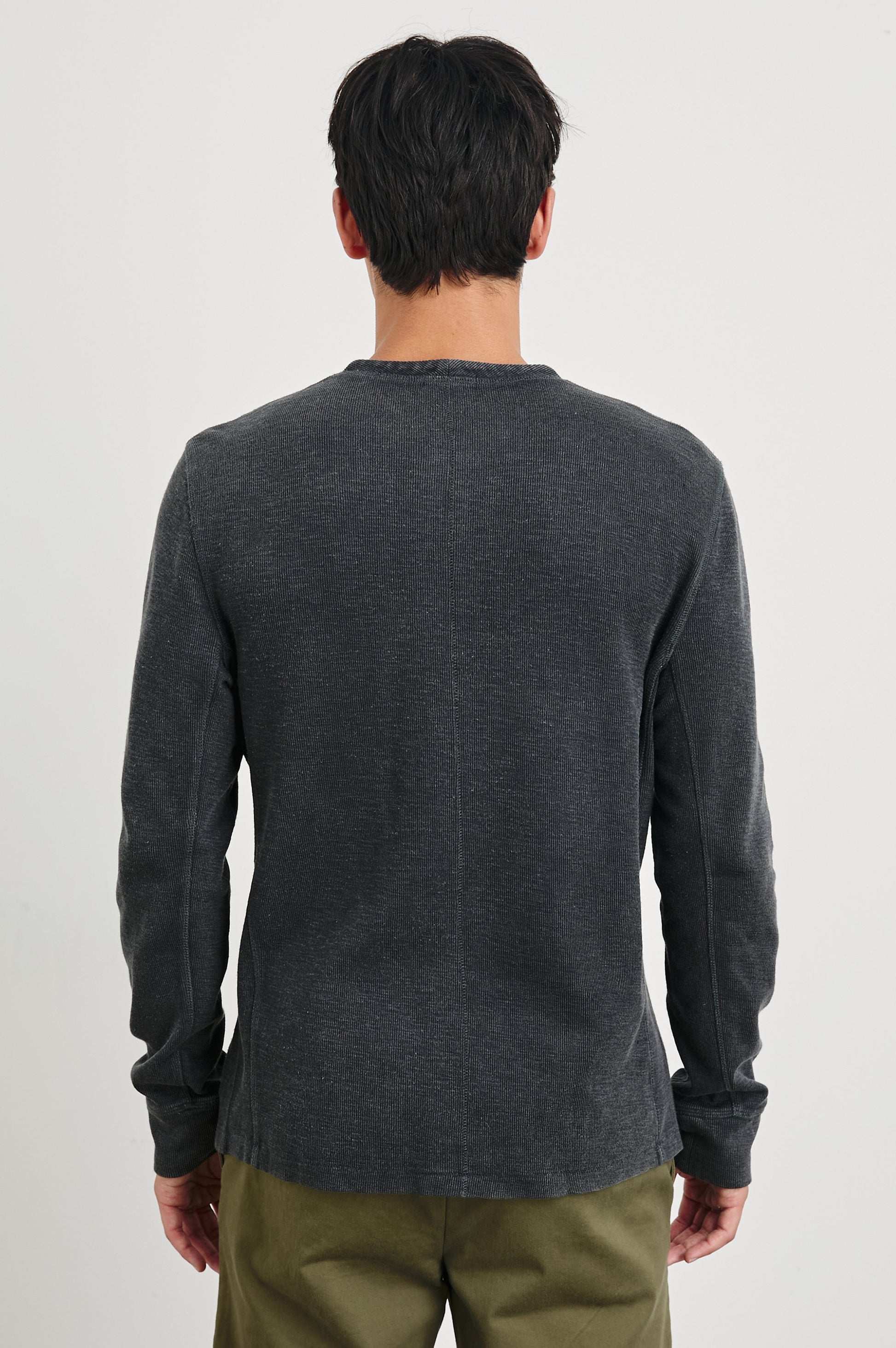 Back view of male model wearing Rails Soto long-sleeve henley in washed black with olive pants