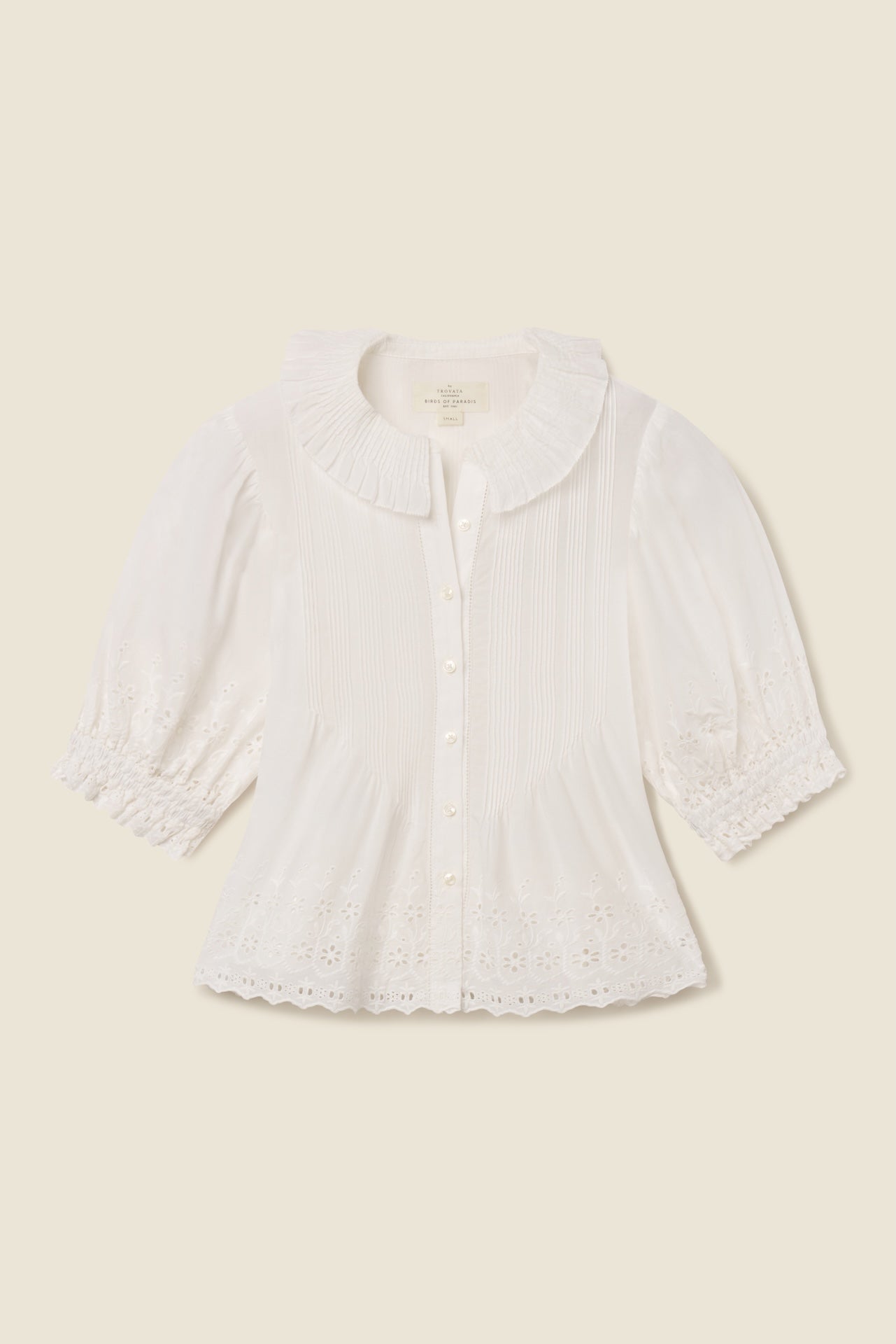 White eyelet cotton blouse with button front, three quarter sleeves, and scalloped hem