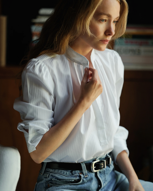 Woman wearing Cissa white tonal striped puff sleeve shirt with collar, styled with jeans and belt in natural lighting.