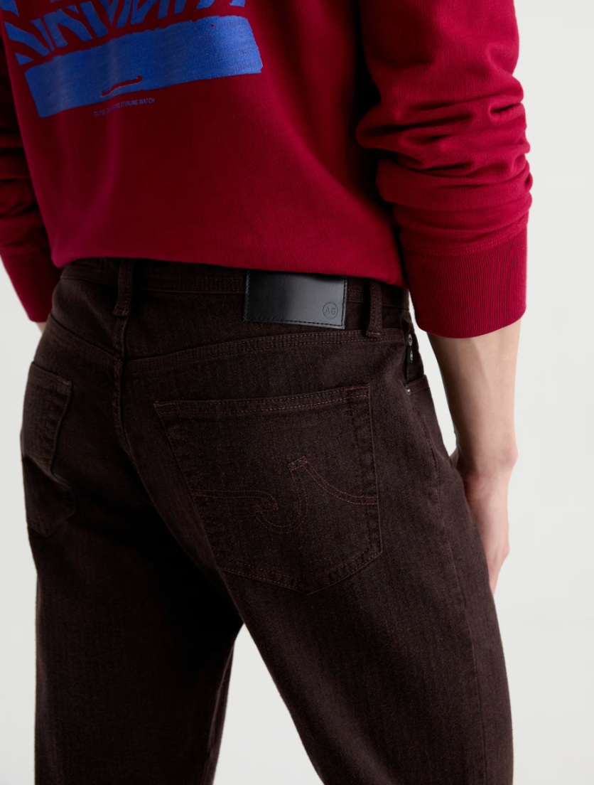 AG Everett straight-leg dark brown jeans shown from behind, featuring a classic five-pocket design with AG branded belt bu...