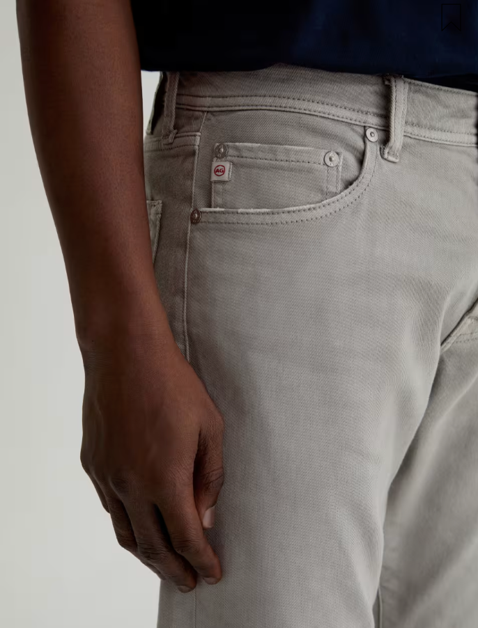 AG Tellis slim fit jeans in light grey denim showing front pocket detail and classic five-pocket styling.