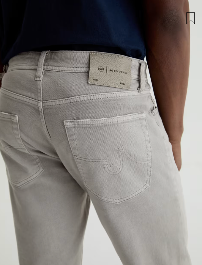 AG Tellis grey slim fit jeans showing back view with branded leather patch and back pockets.