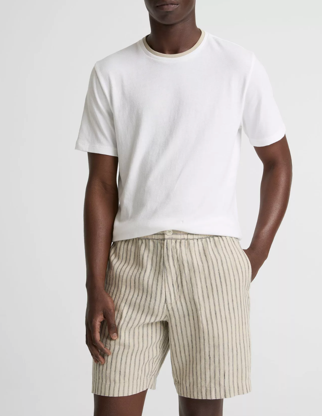 Model wearing Vince loose knit double collar short sleeve crew neck t-shirt in white with striped shorts.