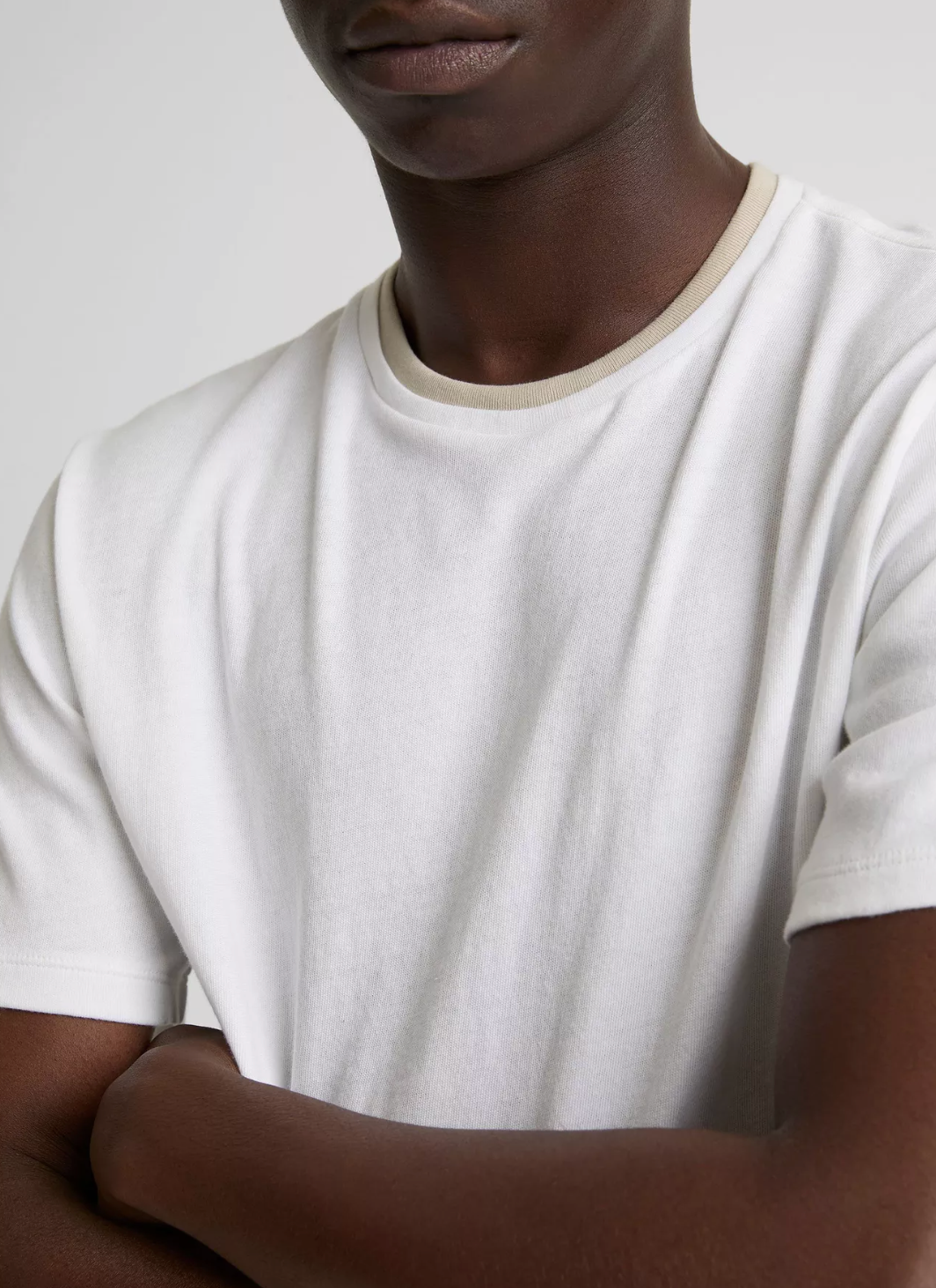 Person wearing a Vince loose knit short-sleeve crew neck t-shirt with distinctive double collar detail in light neutral tone.