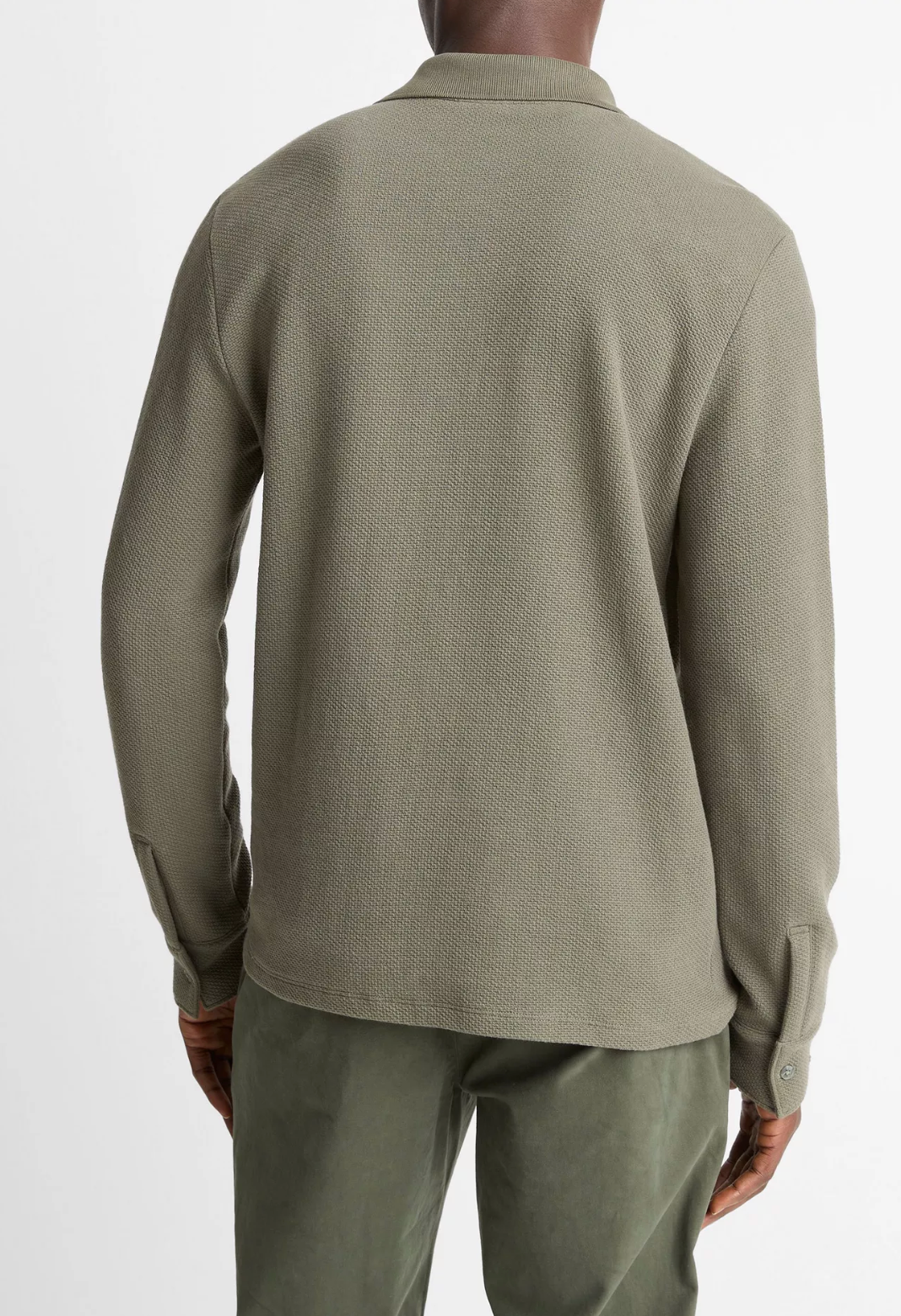 Back view of man wearing Vince long sleeve polo shirt in olive green with textured basket weave fabric.