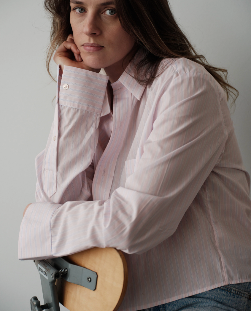 Woman wearing Cissa oversized pink striped button-up shirt with relaxed fit and collar detail.