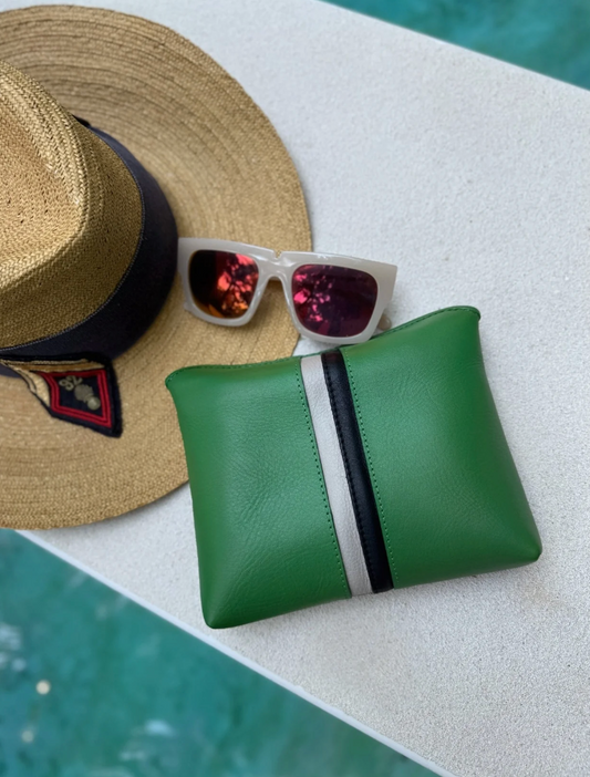 Kempton Small Fold Pouch in kelly green leather with white and black stripe detail, displayed poolside with hat and sungla...