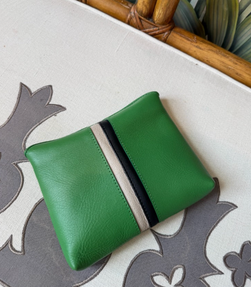 Kempton Small Fold Pouch in Kelly Green leather with contrasting black and cream stripes on floral fabric background.