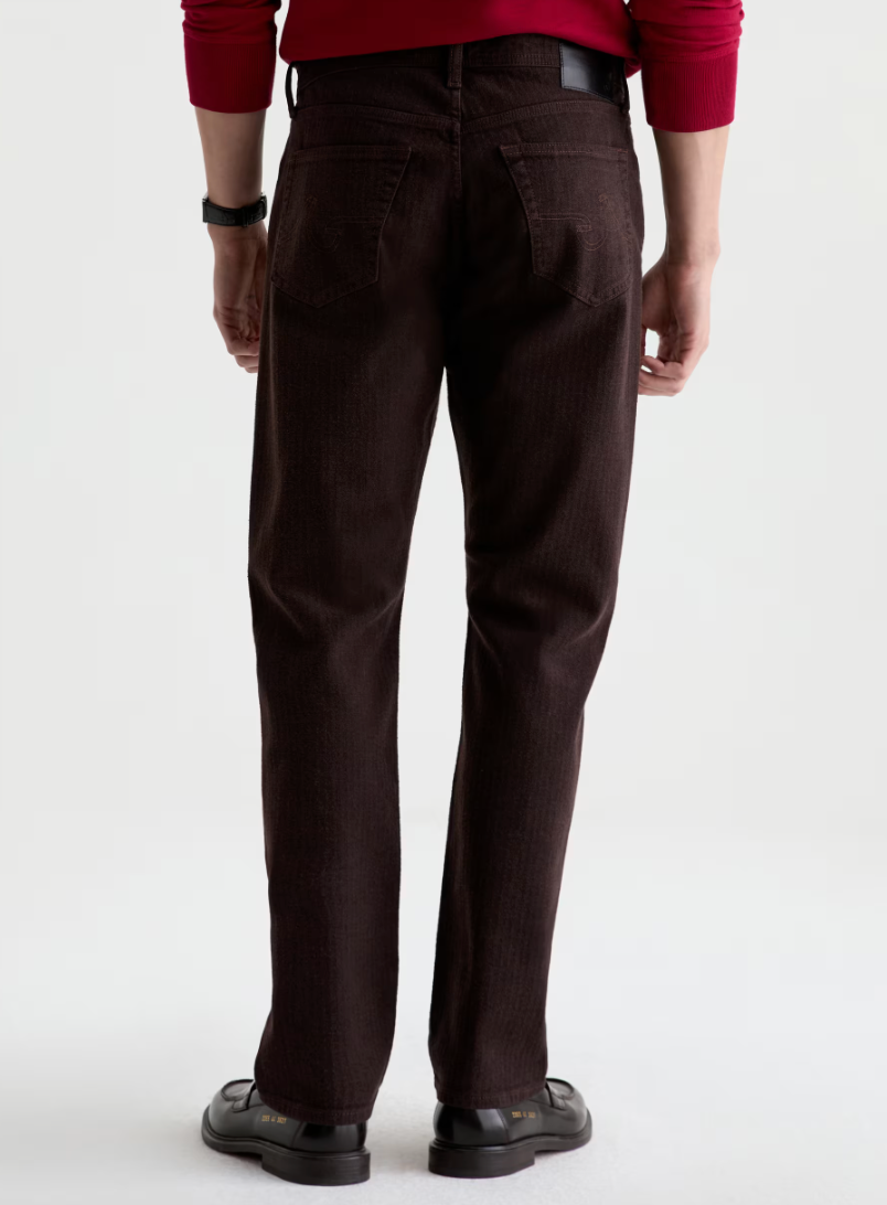 AG Everett straight-leg dark brown jeans shown from behind, featuring classic five-pocket styling and black belt.