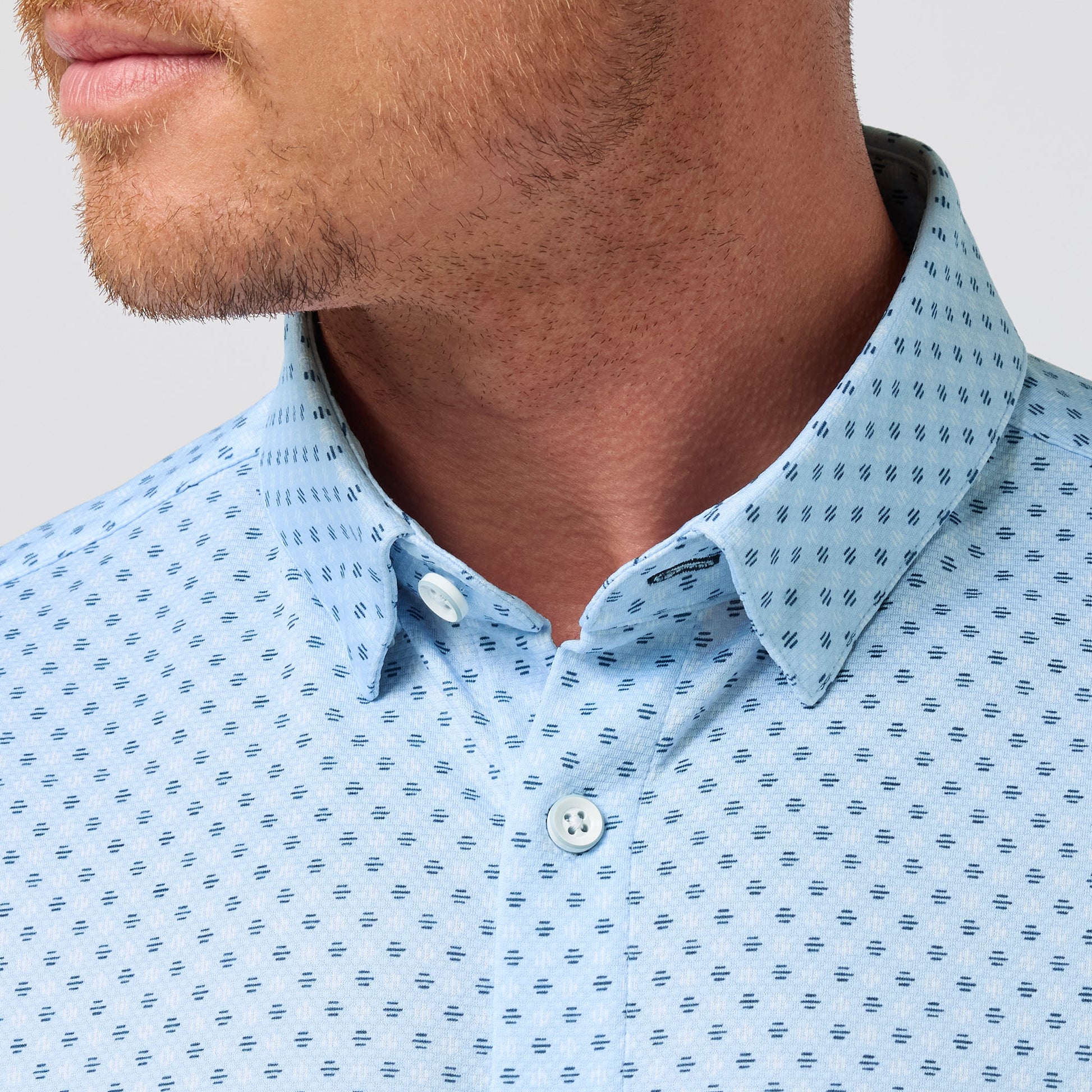 Man wearing light blue short sleeve button-up shirt with small circle dash pattern