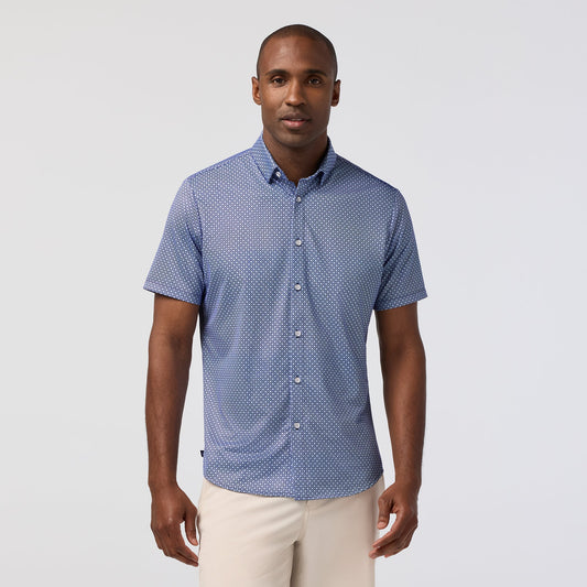 Man wearing navy blue short sleeve button-down shirt with white geometric diamond pattern