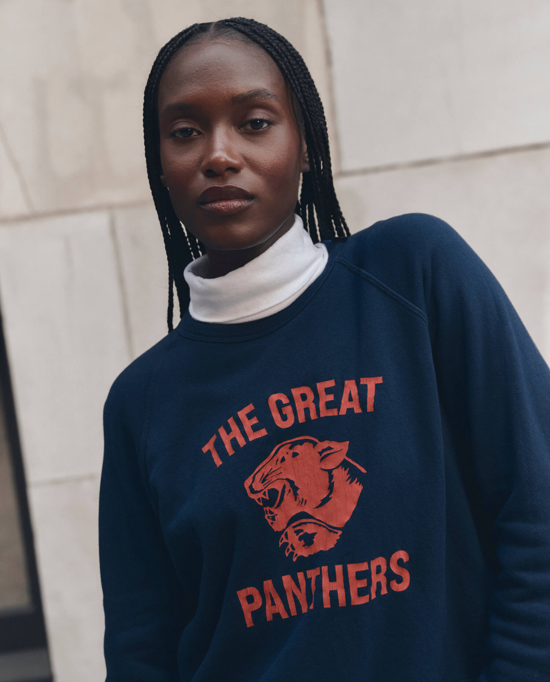Model wearing navy fleece sweatshirt with red Growling Panther graphic and turtleneck underneath