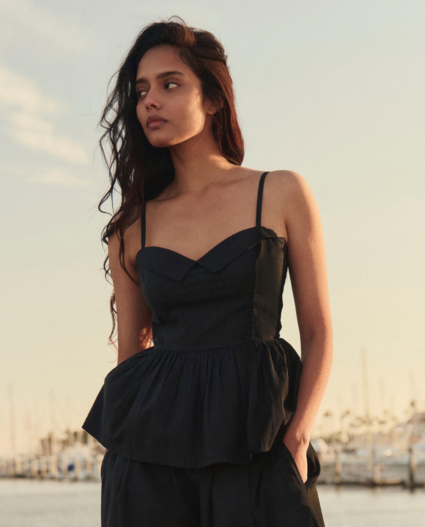 Model wearing black textured verse top with sweetheart neckline and spaghetti straps at marina
